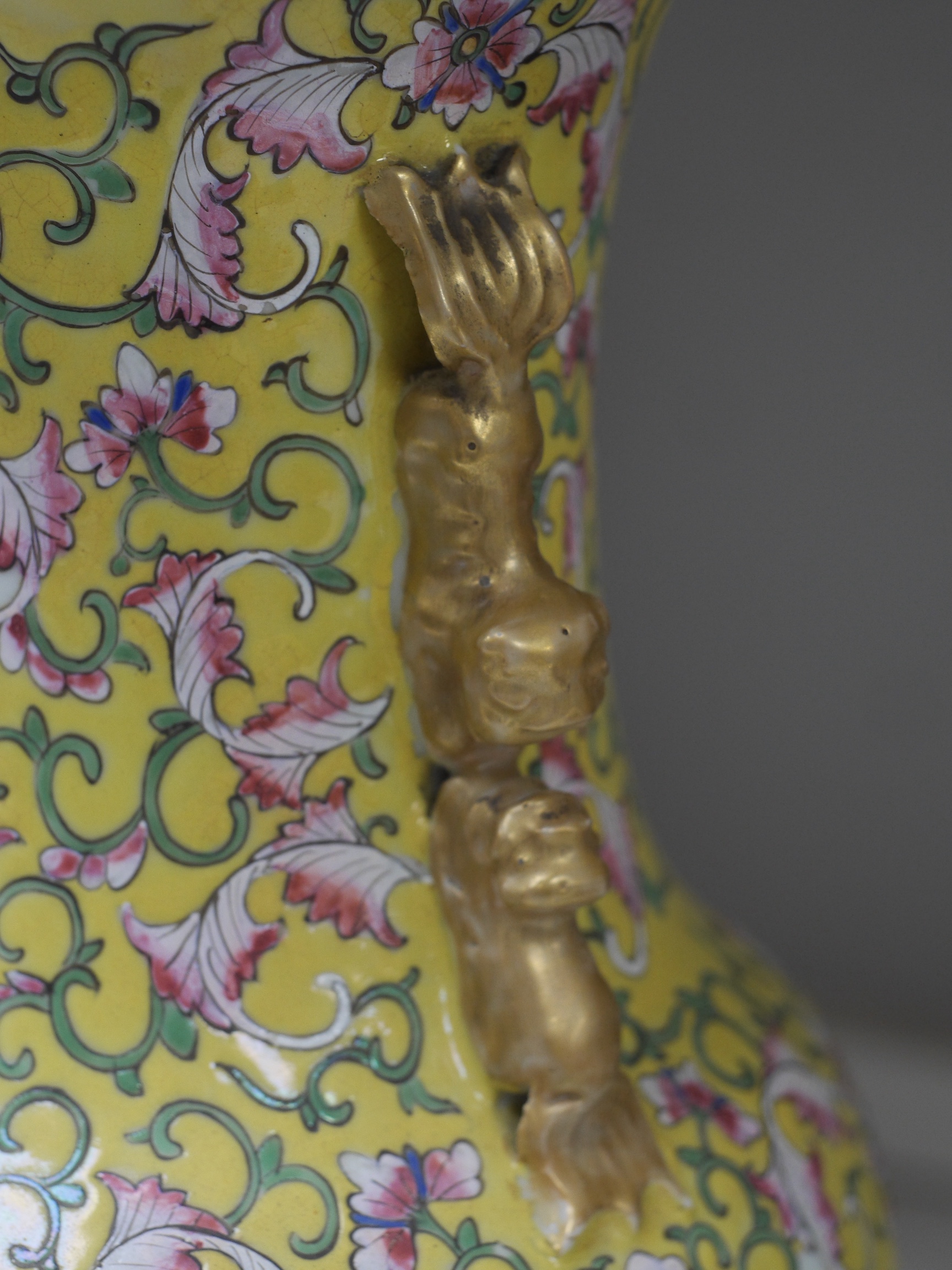 A late 19th century Chinese yellow ground porcelain vase, with gilt chilong handle, decorated with flowers and tendrils, iron red bands to the scalloped neck (including two stands), 35cm high. Condition - chip to top edg